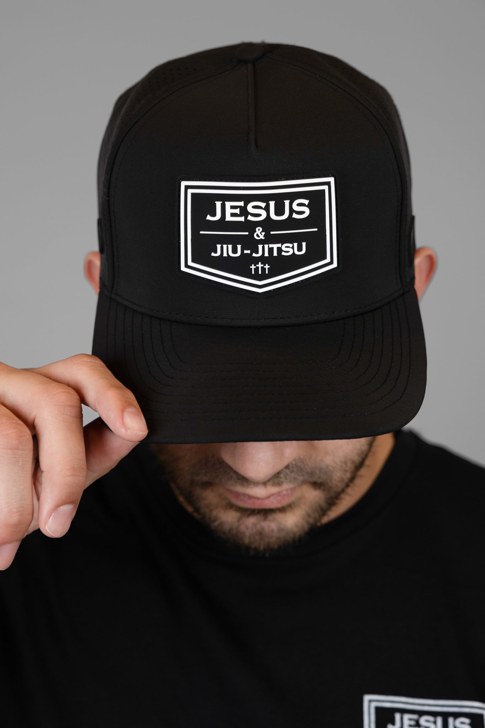 Man wearing black hat with "JESUS & JIU-JITSU" logo on front