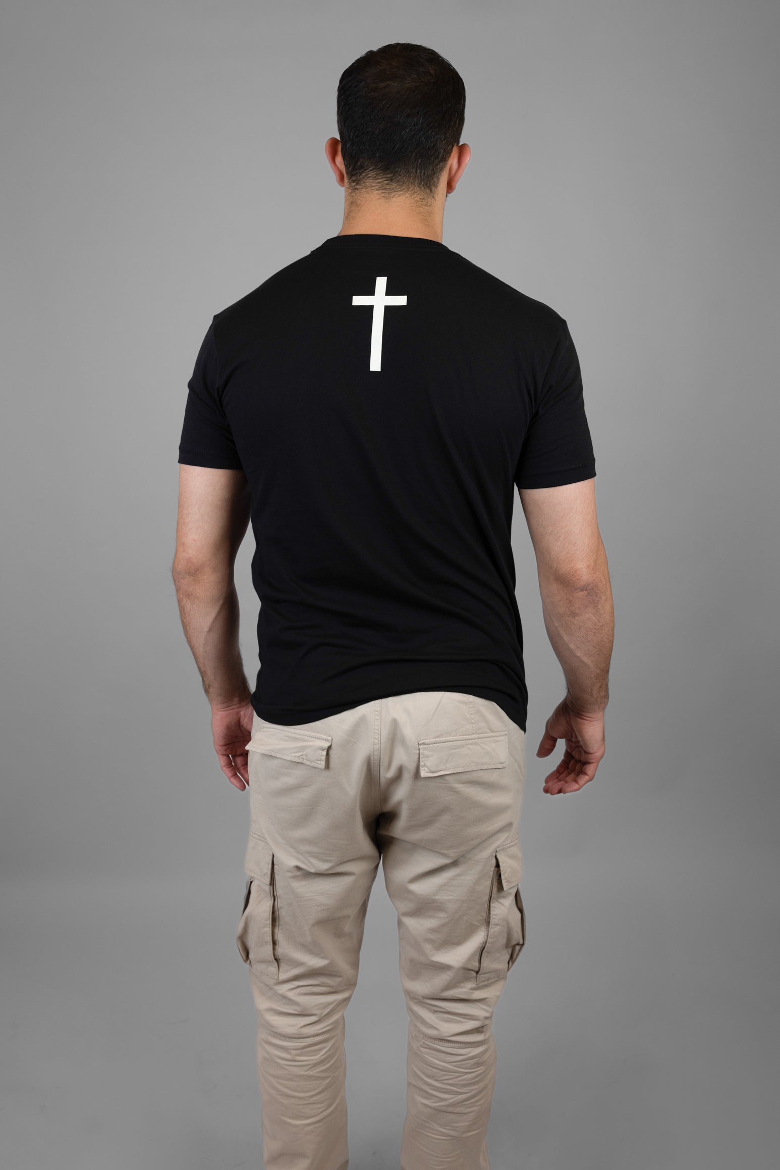 Man wearing black tee with white cross on back