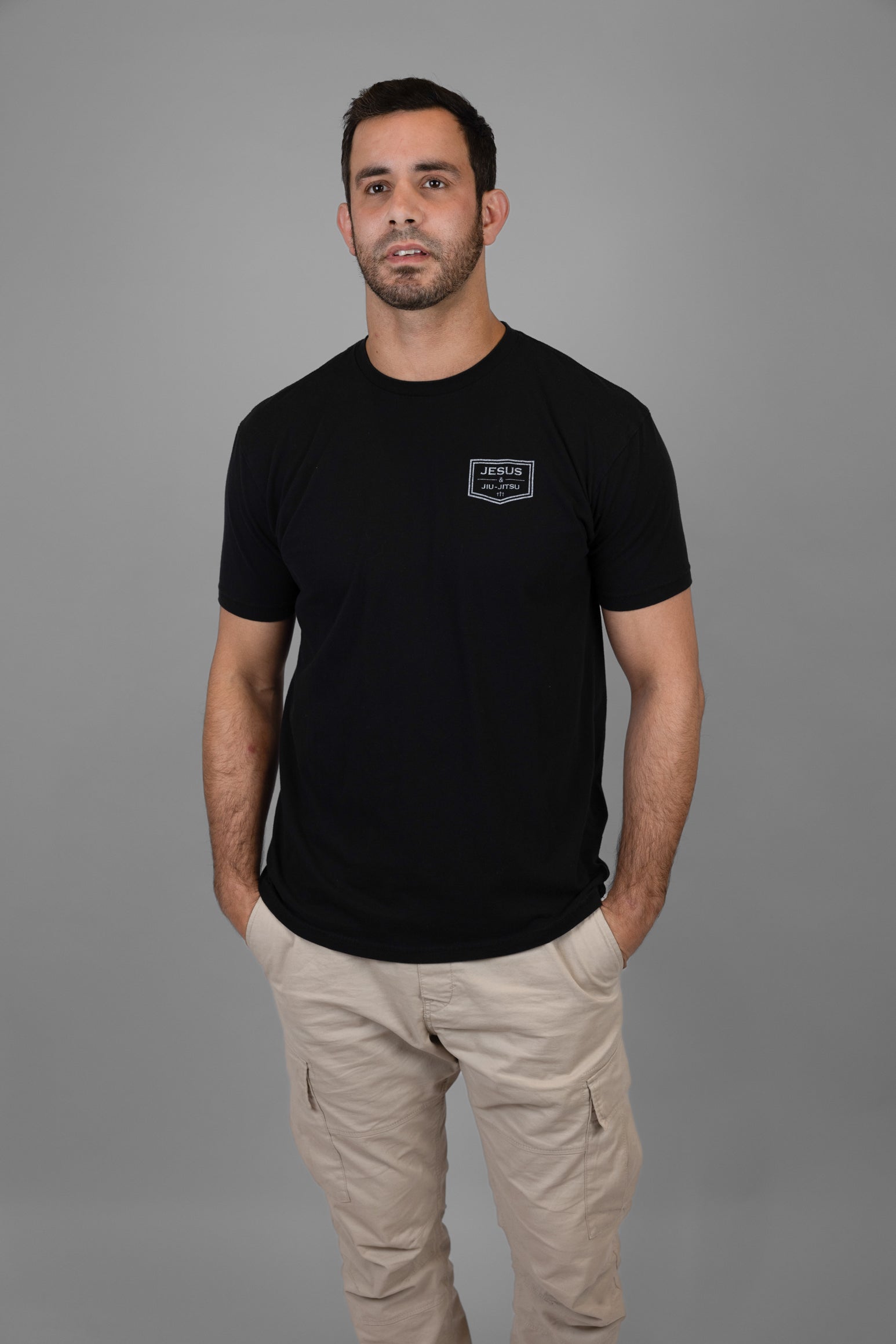 Person wearing a black t-shirt with "JESUS & JIU-JITSU" logo on left chest