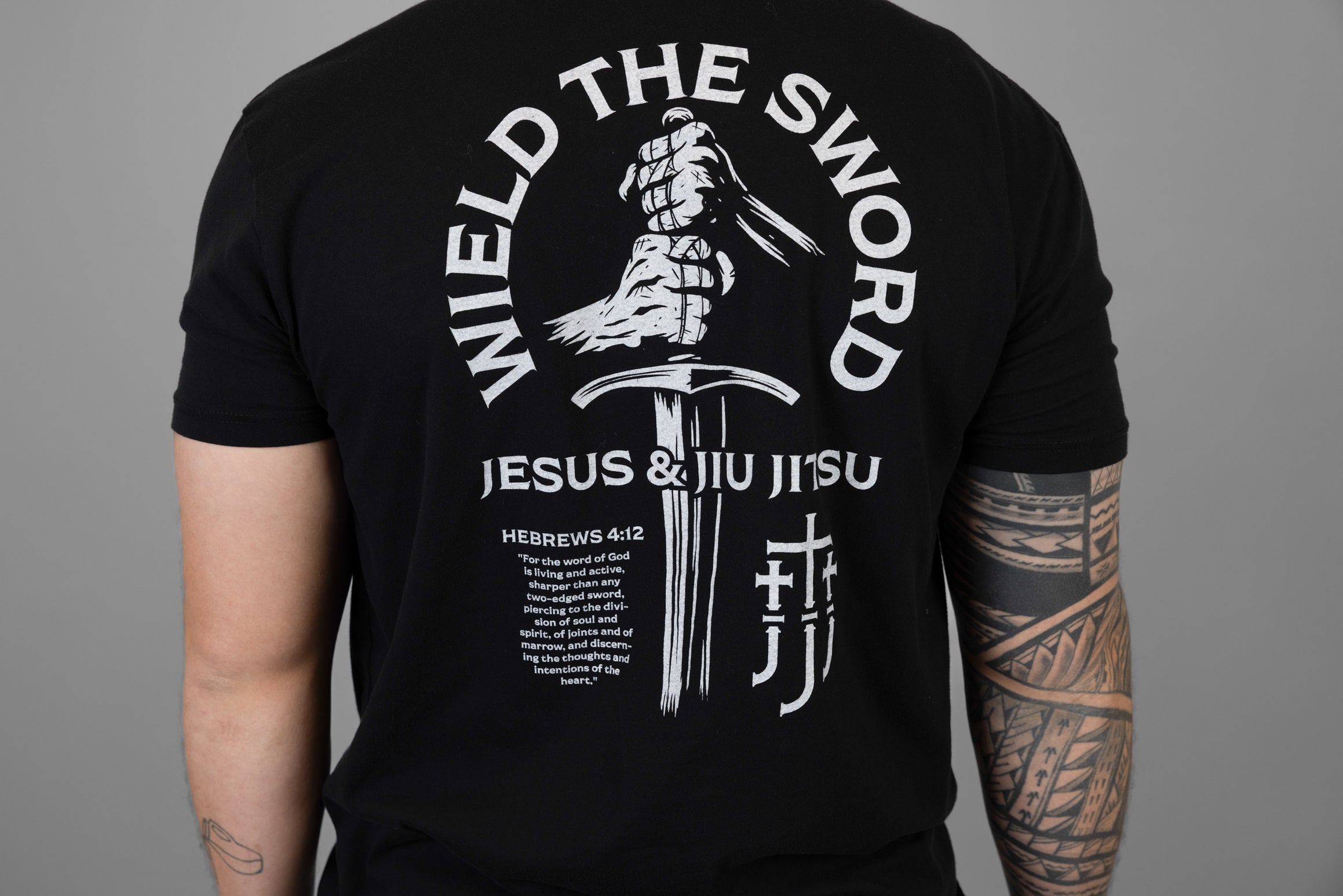 Black t-shirt with white WIELD THE SWORD graphic and text on a gray background