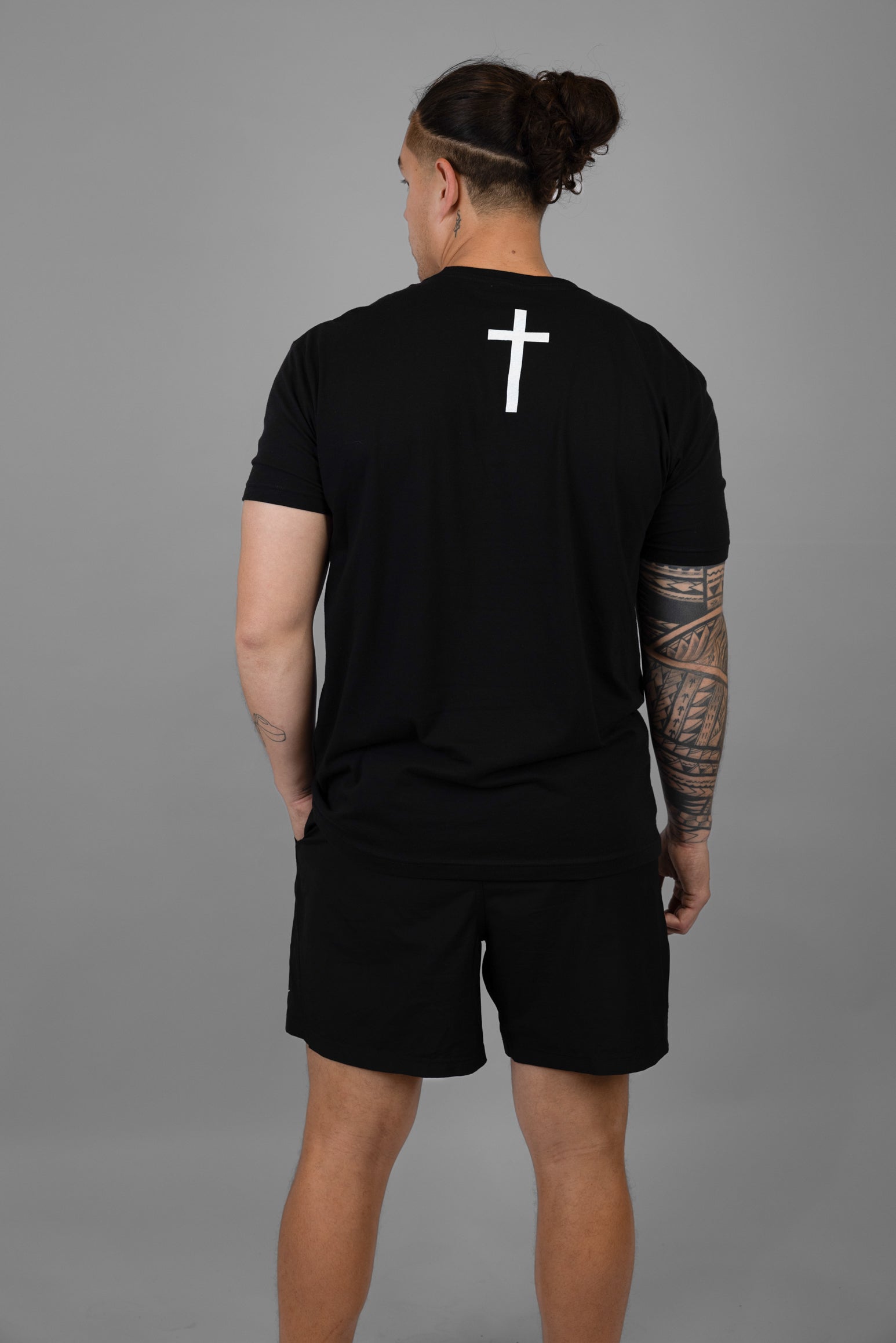 Rear view of man wearing black shirt with white cross