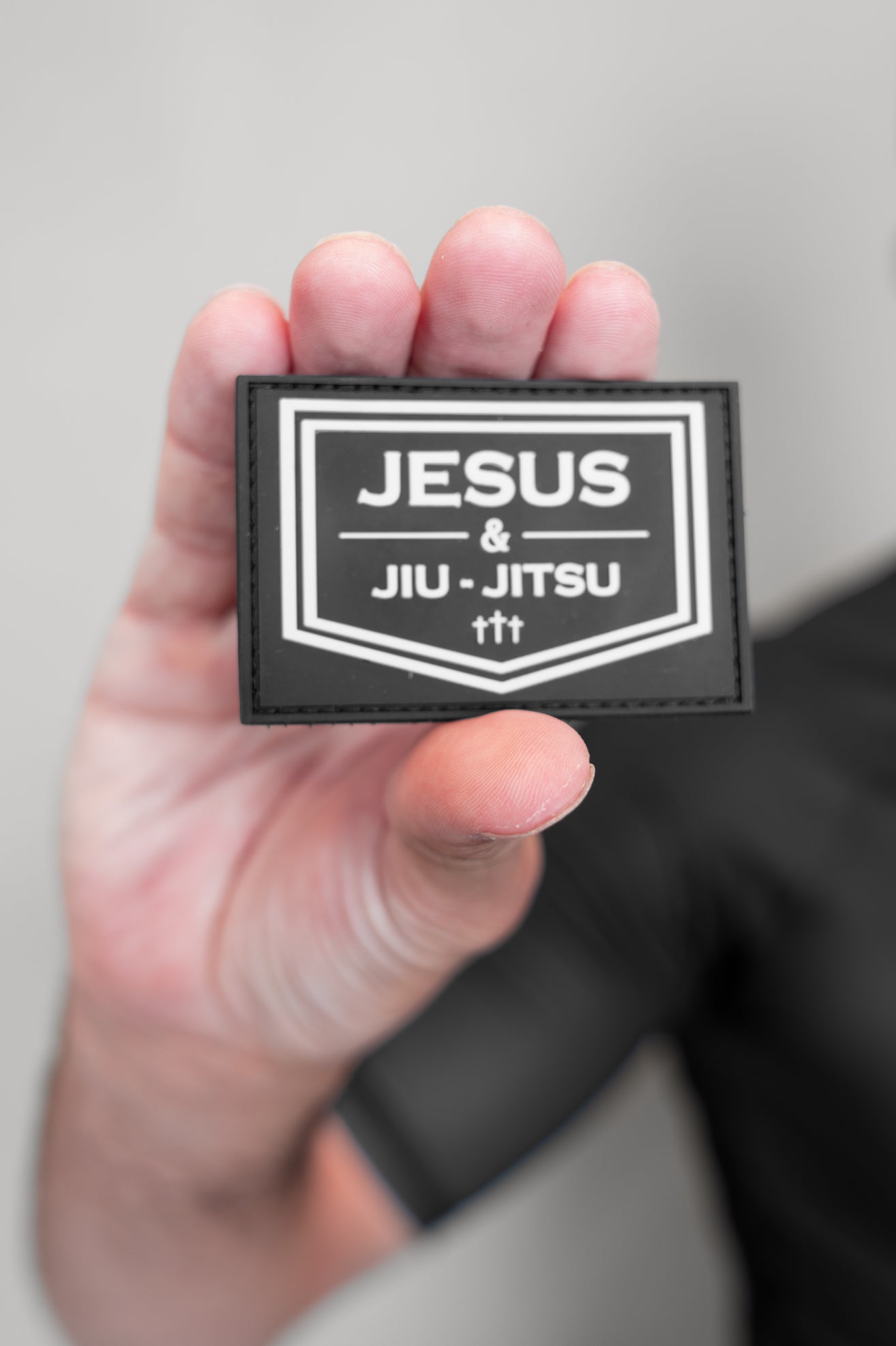 Person holding Velcro patch JJJ logo