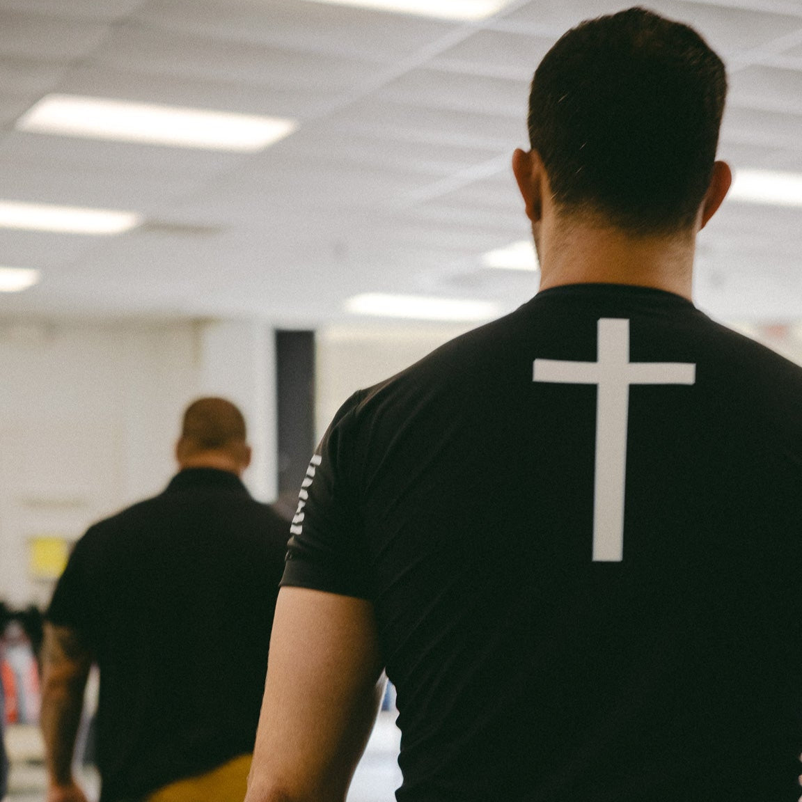 Man wearing rashguard with cross on back