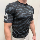 Man wearing black tiger camo rashguard with JJJ logo on left chest and right shoulder