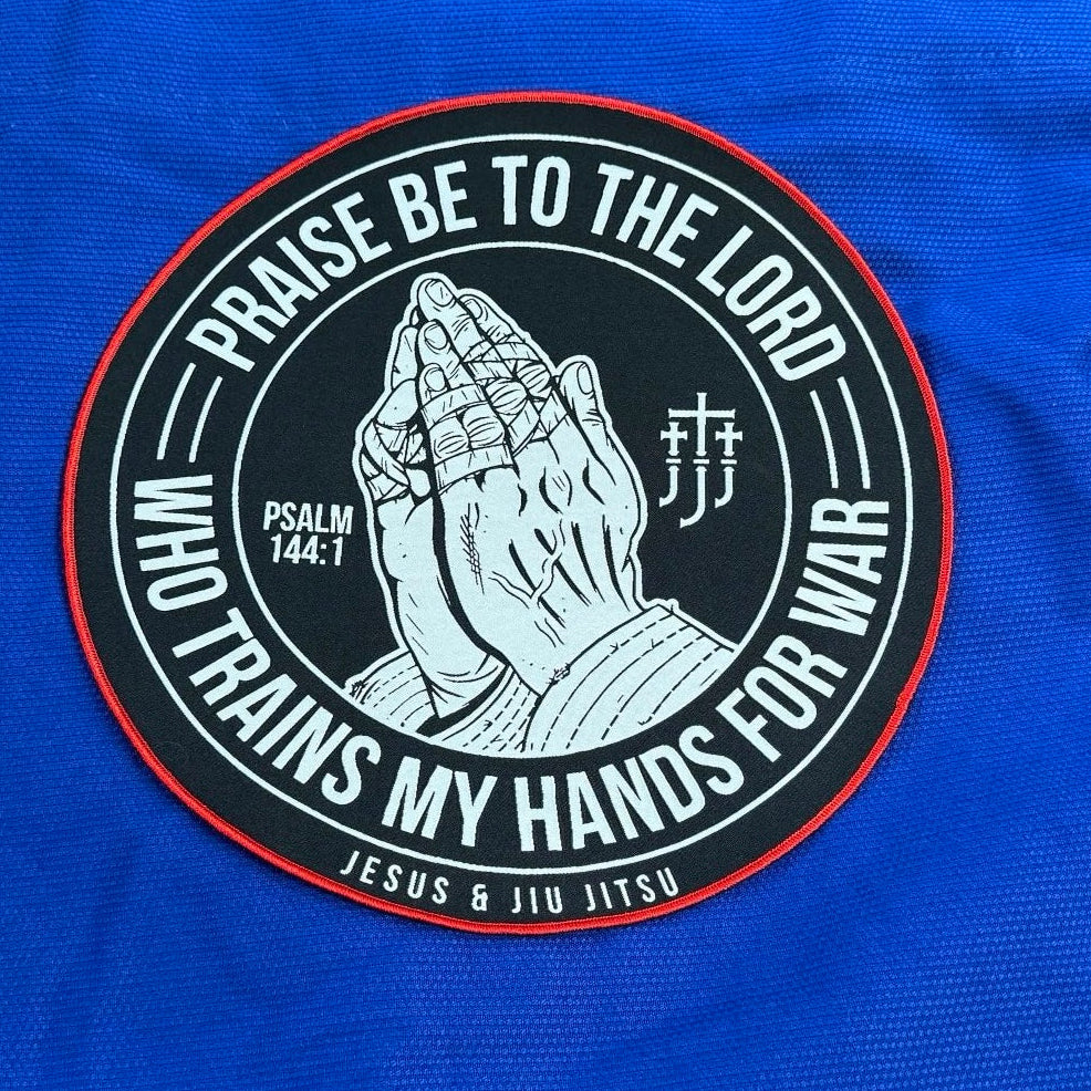 Patch with praying hands design and "PRAISE BE TO THE LORD WHO TRAINS MY HANDS FOR WAR" text