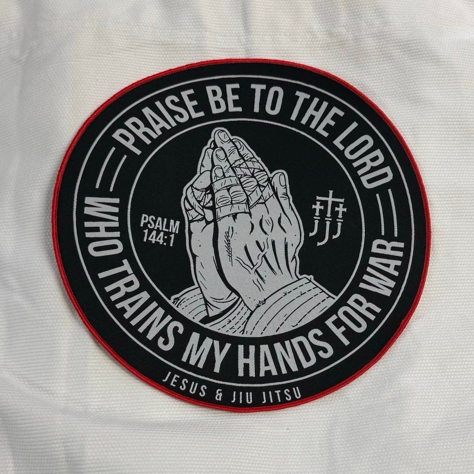 Patch with praying hands design and "PRAISE BE TO THE LORD WHO TRAINS MY HANDS FOR WAR" text