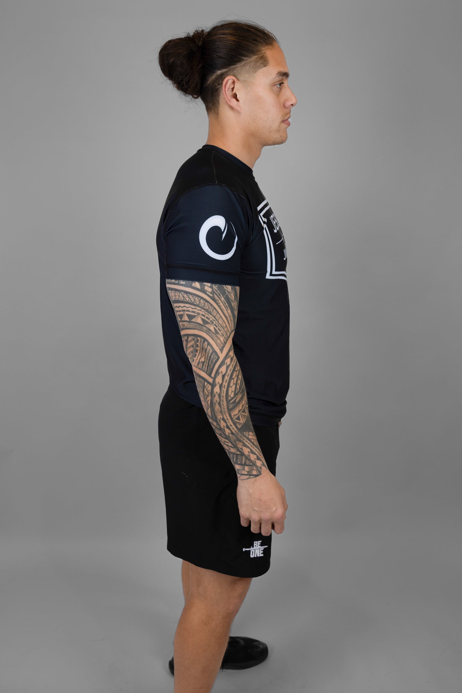 Man wearing rashguard with white origin logo on right shoulder