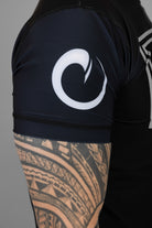 Man wearing rashguard with white origin logo on right shoulder