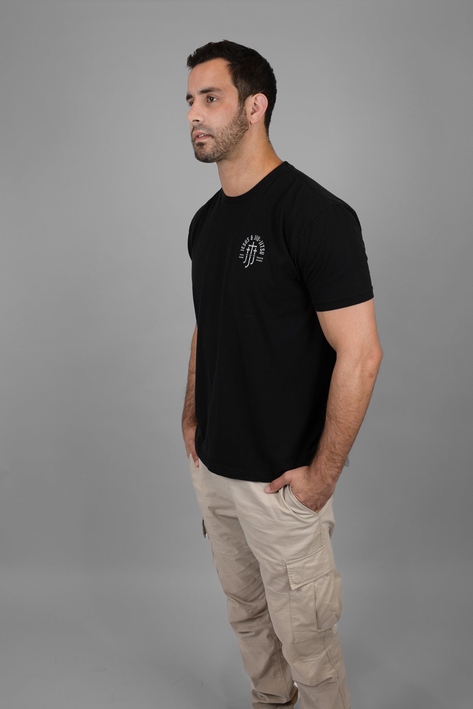 Man wearing a black t-shirt with a JJJ logo on a gray background