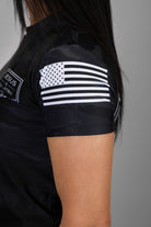 American flag on left shoulder of black tiger camo rashguard