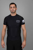 Man wearing black Rashguard with "JESUS & JIU-JITSU" logo on left chest