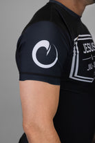 Man wearing rashguard with white origin logo on right shoulder