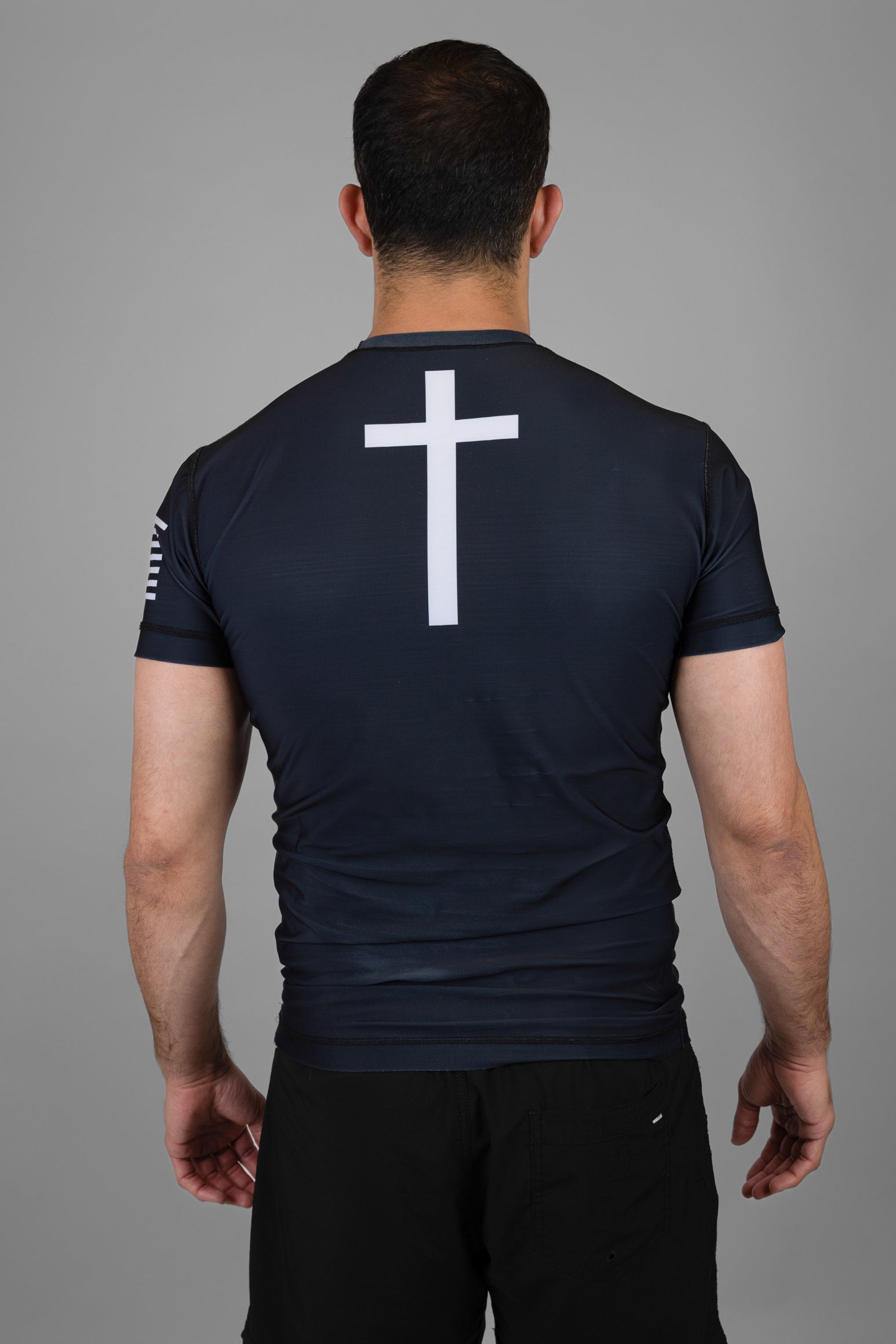 Man wearing rashguard with cross on back