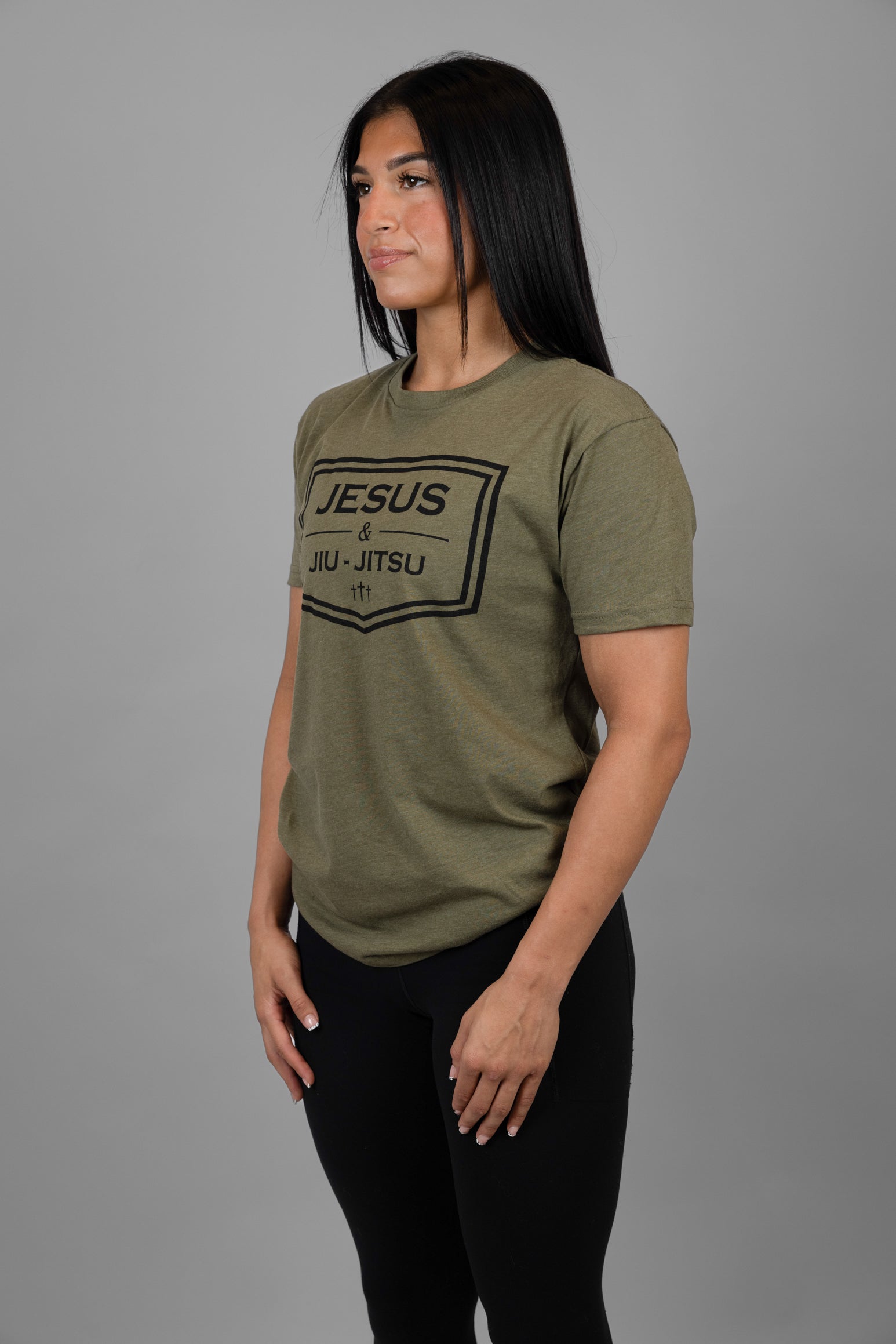 Woman wearing green tee with black JESUS & JIU-JITSU logo
