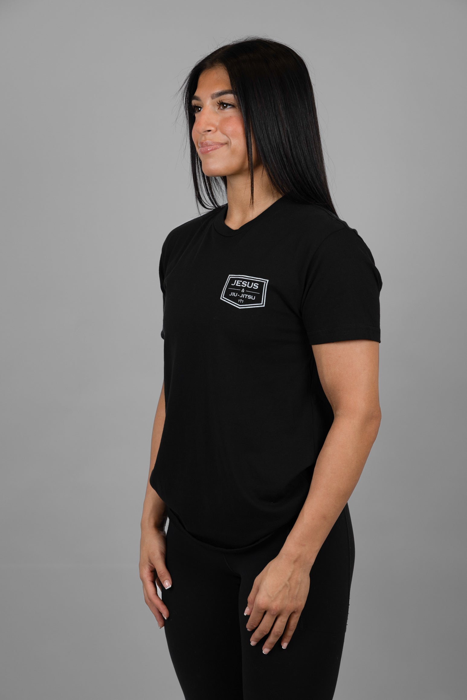 Person wearing a black t-shirt with "JESUS & JIU-JITSU" logo on left chest