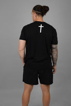 Rear view of man wearing black shirt with white cross