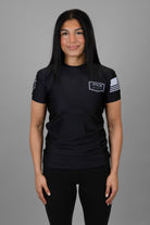 Woman wearing black Rashguard with "JESUS & JIU-JITSU" logo on left chest