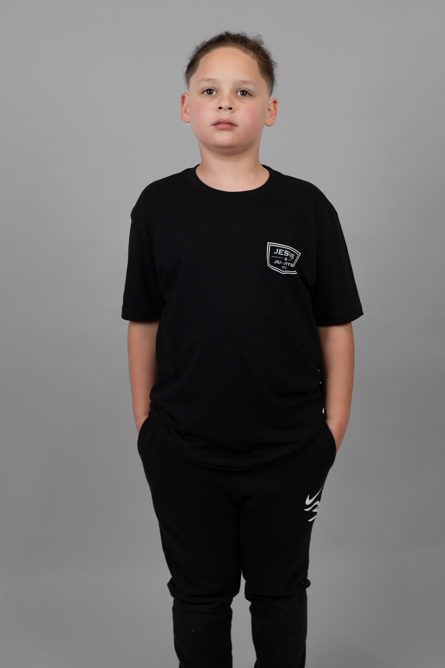 child wearing black tee with JJJ logo on left chest