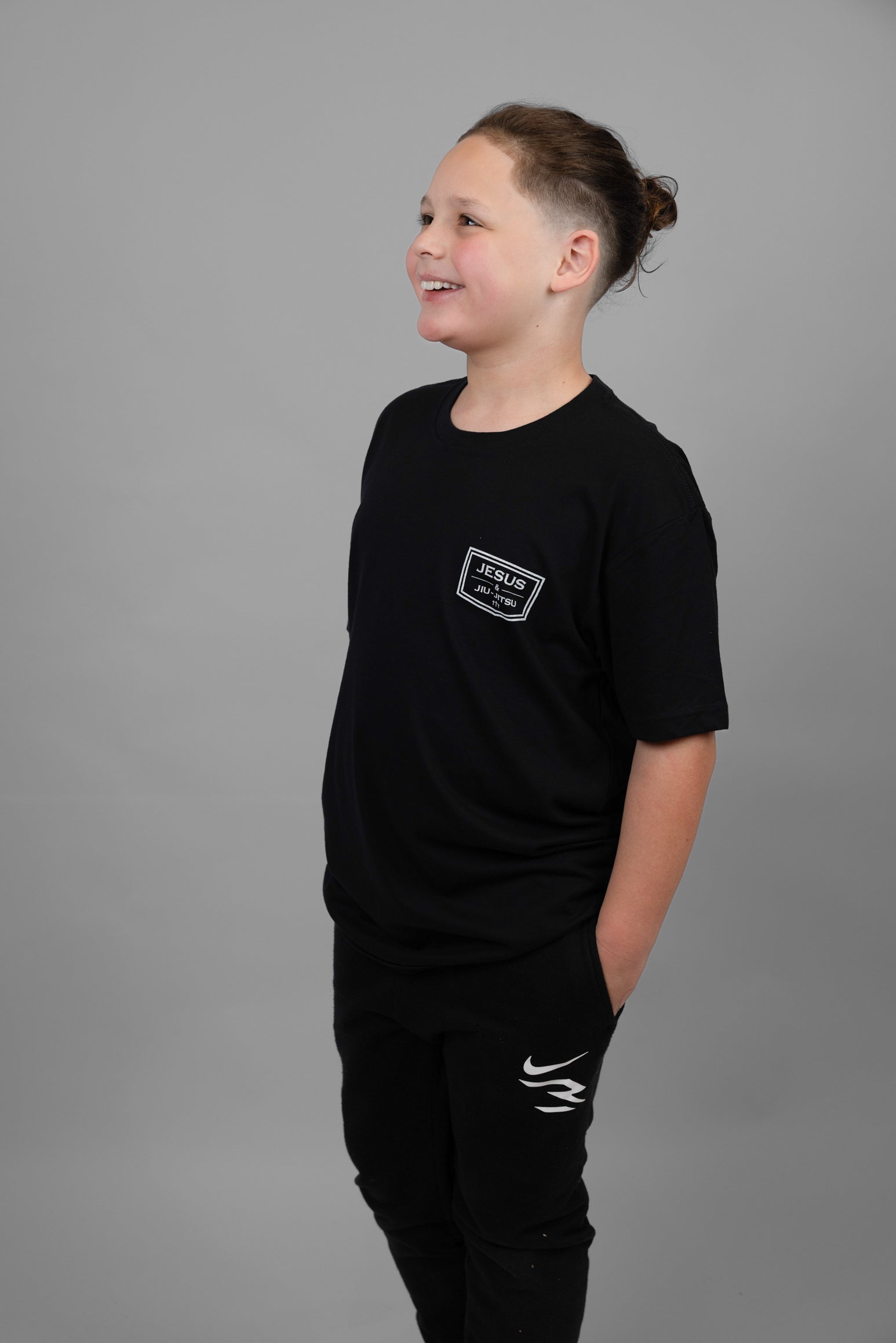 child wearing black tee with JJJ logo on left chest