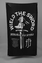 Black flag with hands holding sword graphic with text "WIELD THE SWORD JESUS & JIU JITSU"