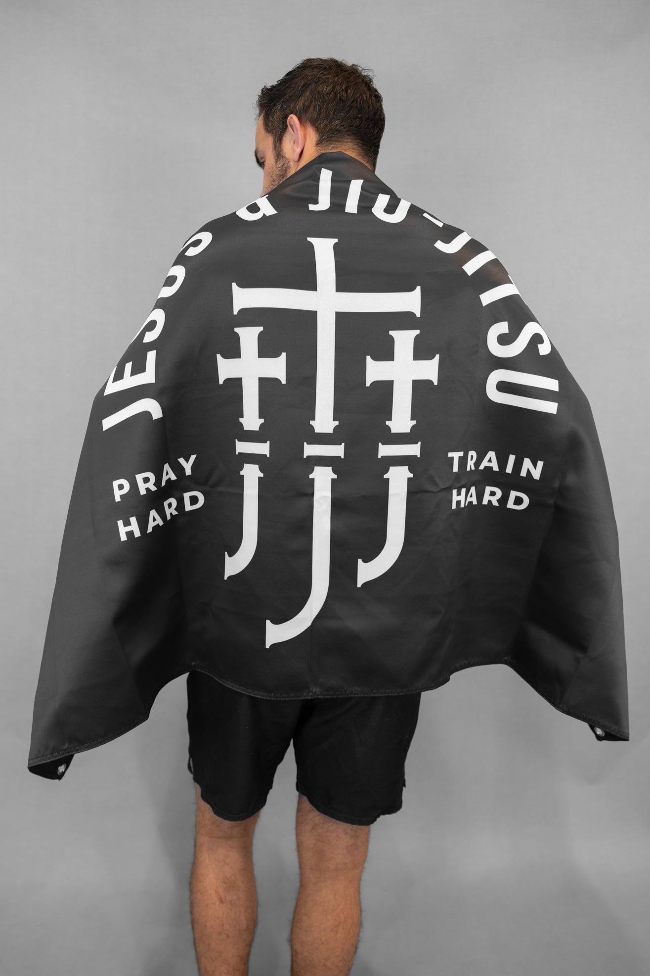 Man wearing Black flag with Jesus & Jiu Jitsu logo featuring "PRAY HARD TRAIN HARD" text