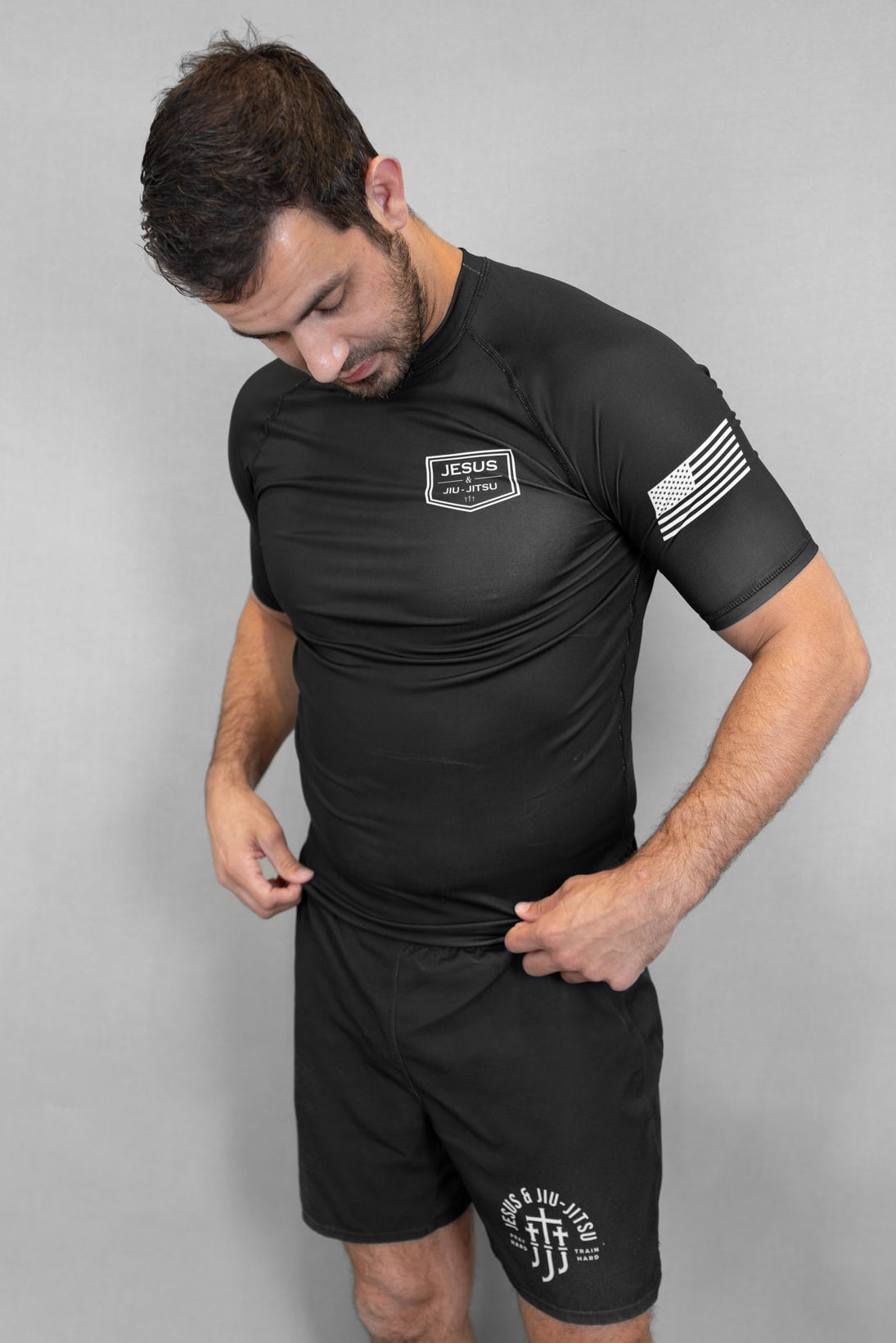 Man wearing black rashguard with JJJ logo on left chest