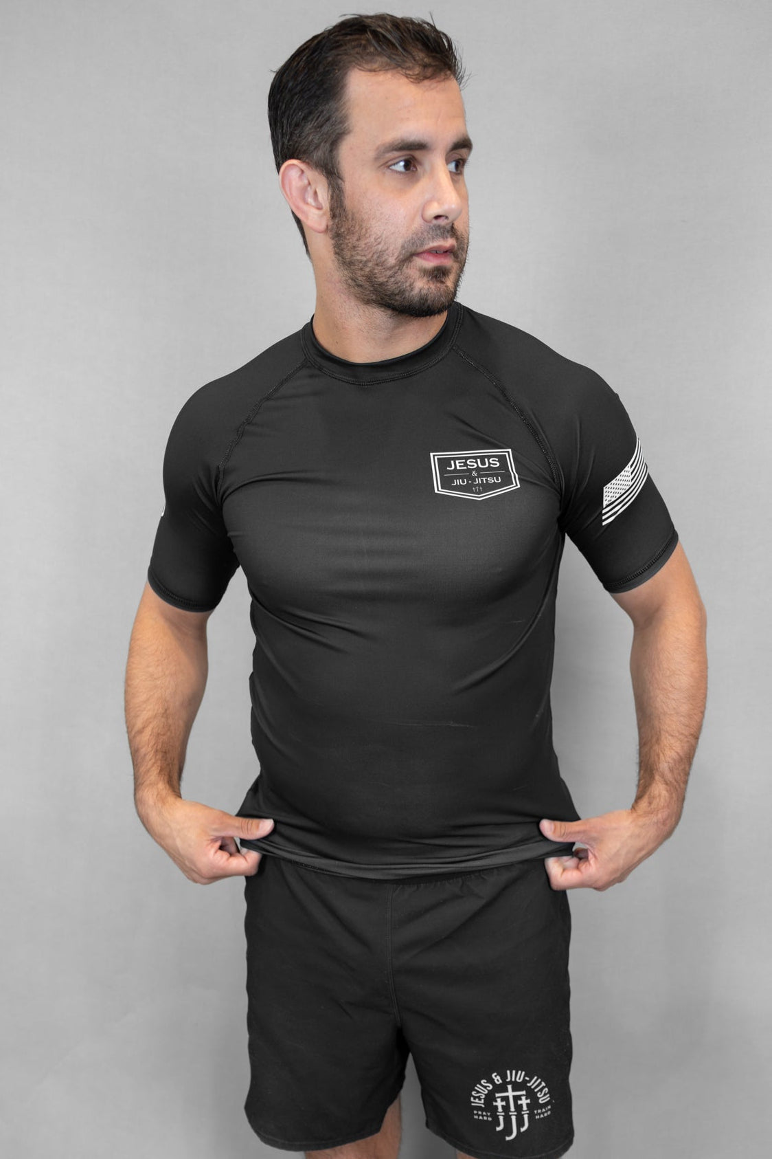 Man wearing black rashguard with JJJ logo on left chest