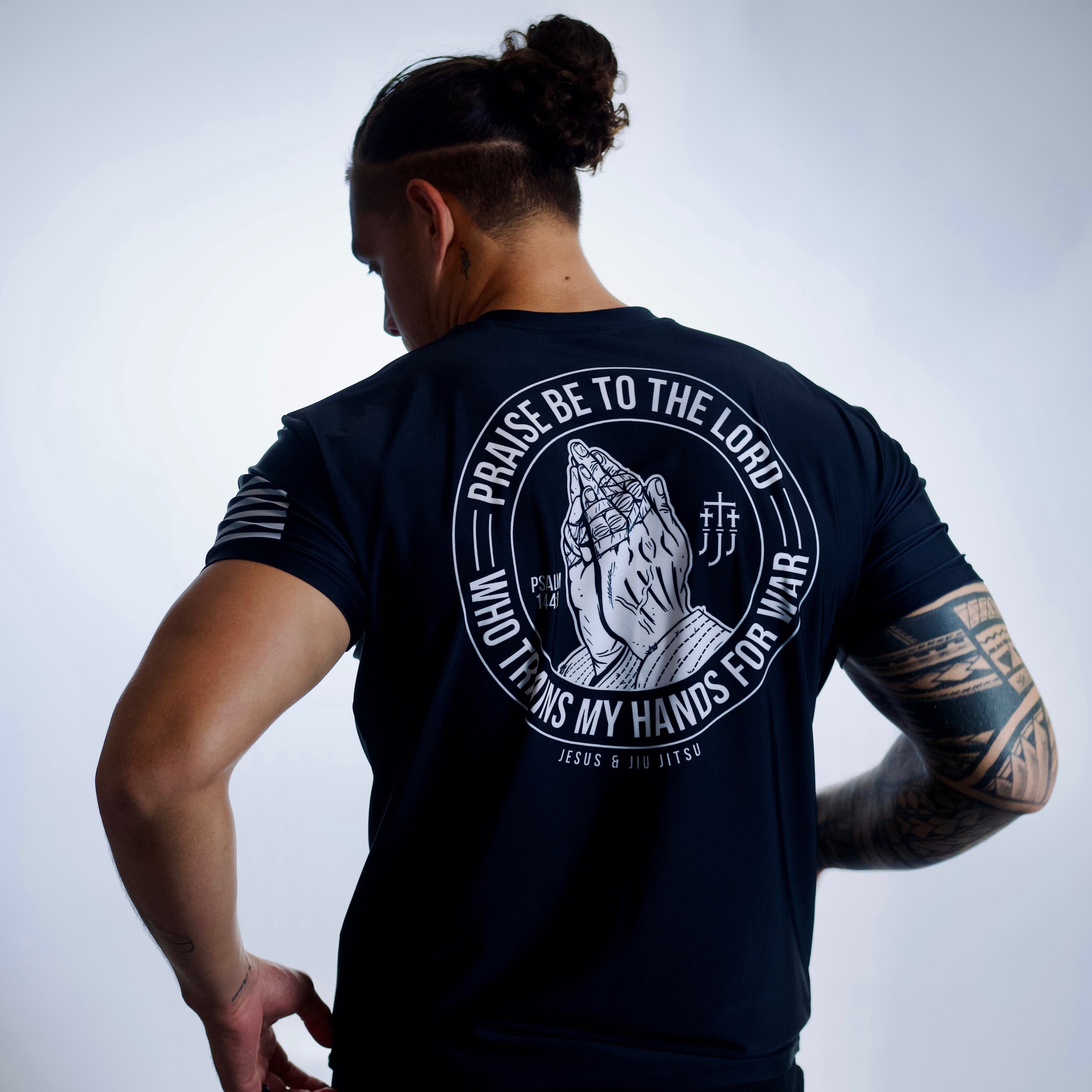 man wearing rashguard with praying hands graphic on back