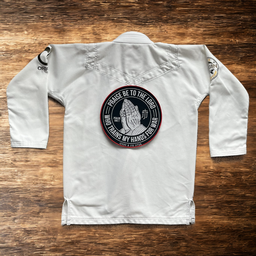 10in Patch with praying hands design and "PRAISE BE TO THE LORD WHO TRAINS MY HANDS FOR WAR" text on a white gi